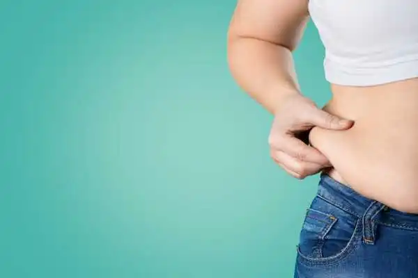Image of woman pinching her love handles to show weight gain Chelmsford